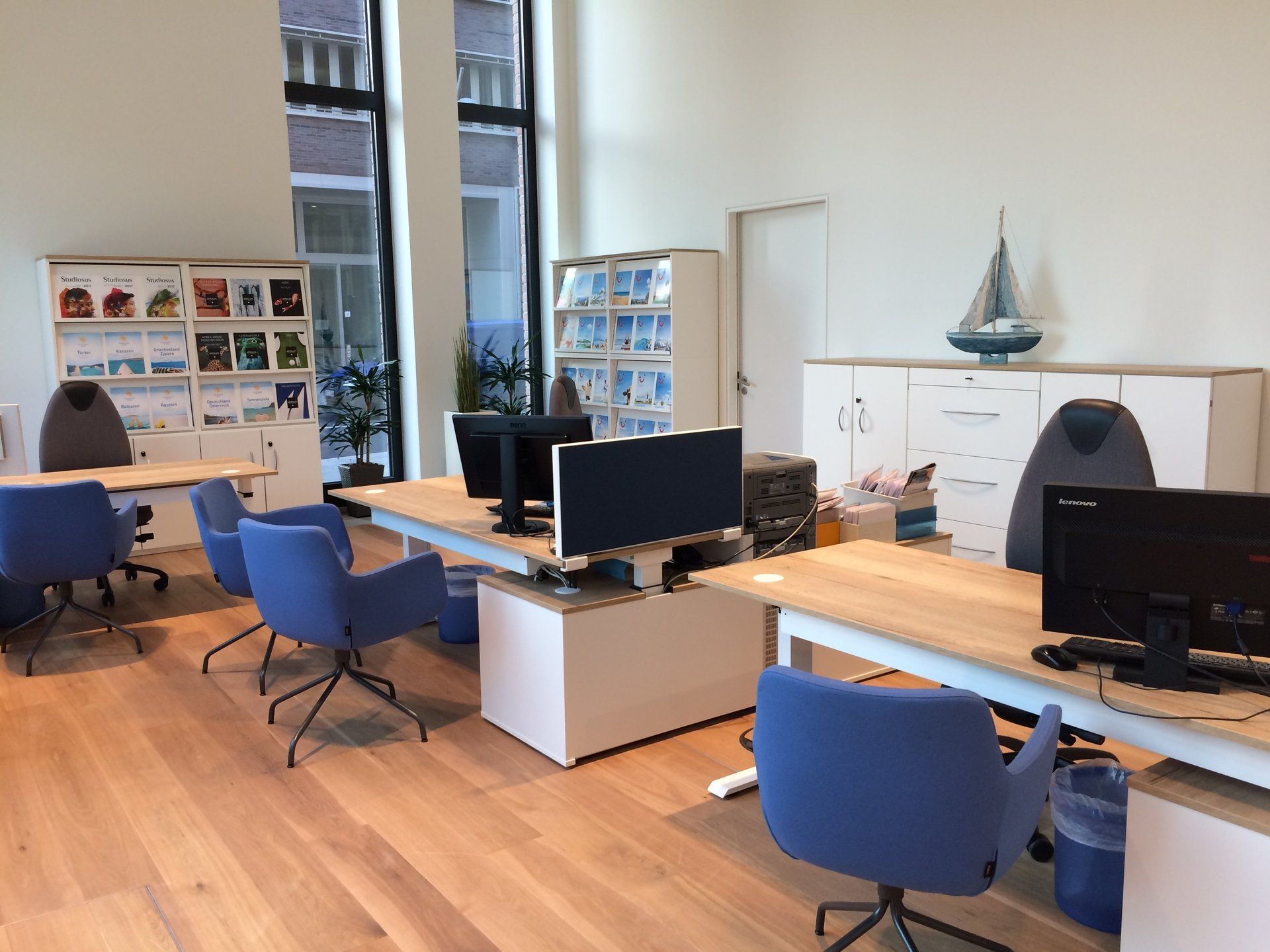 Ein Raum mit vielen Schreibtischen und Stühlen mit Computern darauf