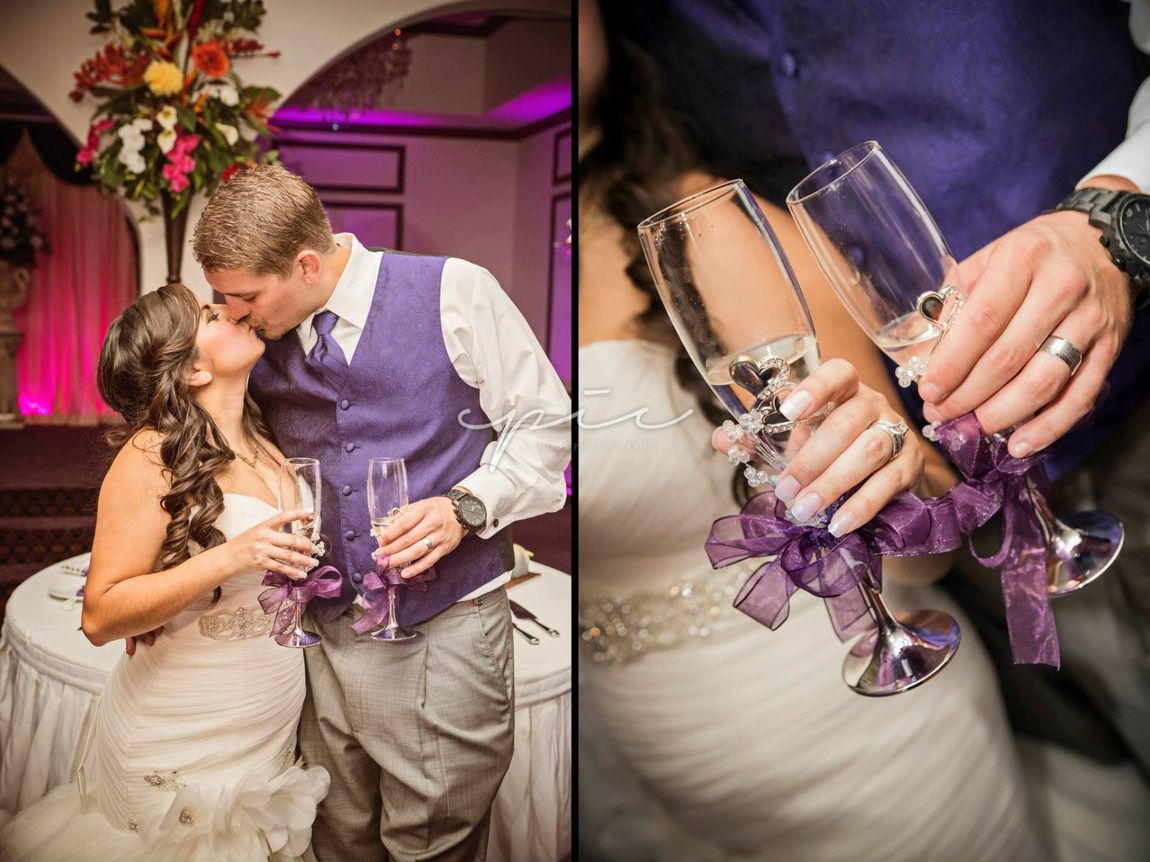 A bride and groom are kissing and holding champagne glasses