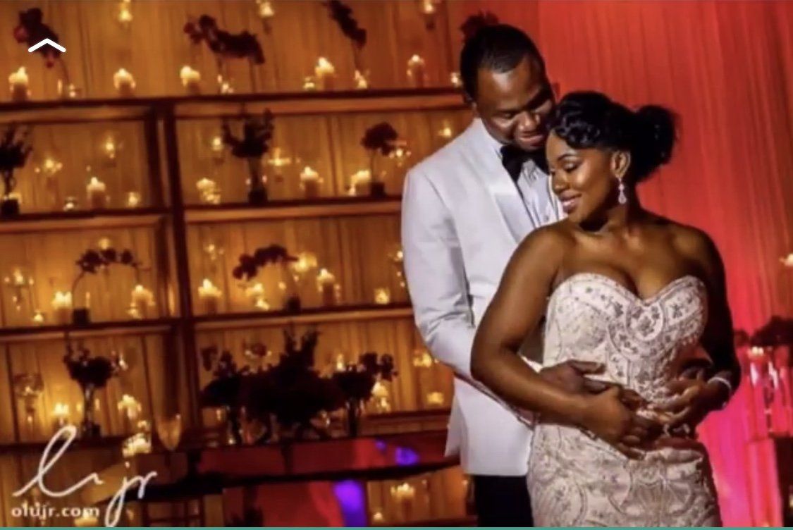 A bride and groom are posing for a picture at their wedding