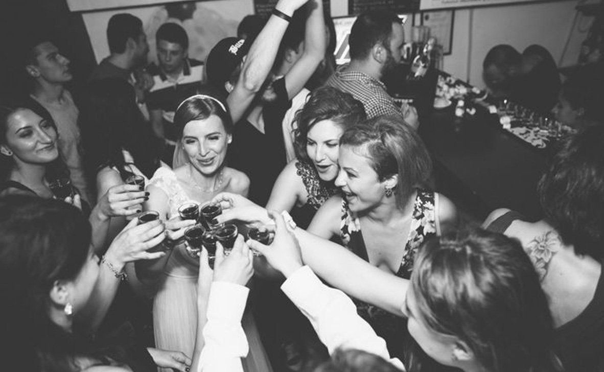 A black and white photo of a group of people dancing at a party.