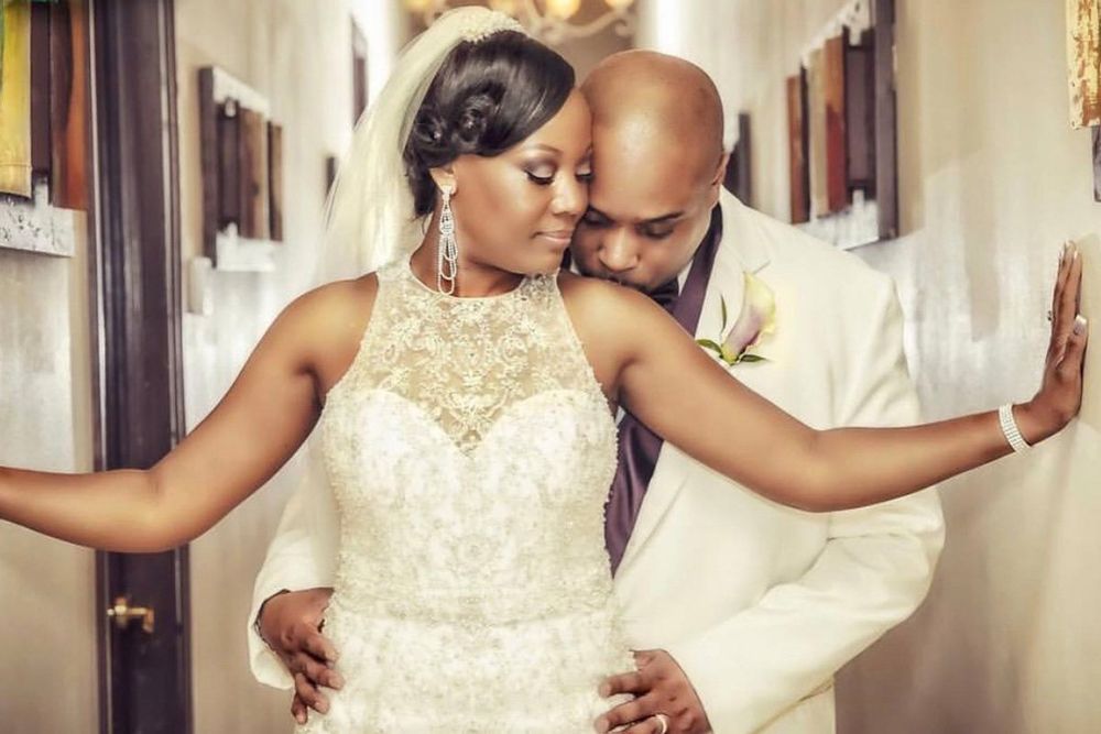 A bride and groom are posing for a picture in a hallway