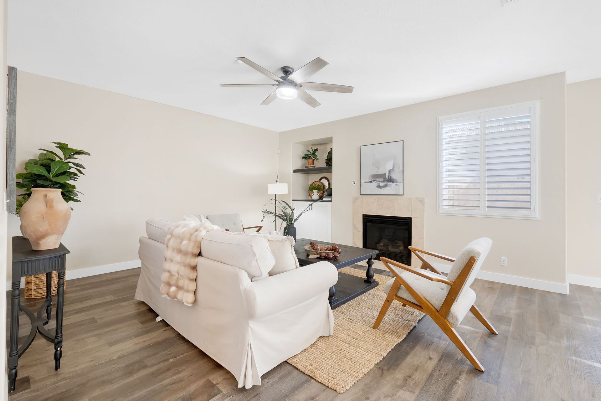 Living room with white sofa, fireplace, and hardwood floors.