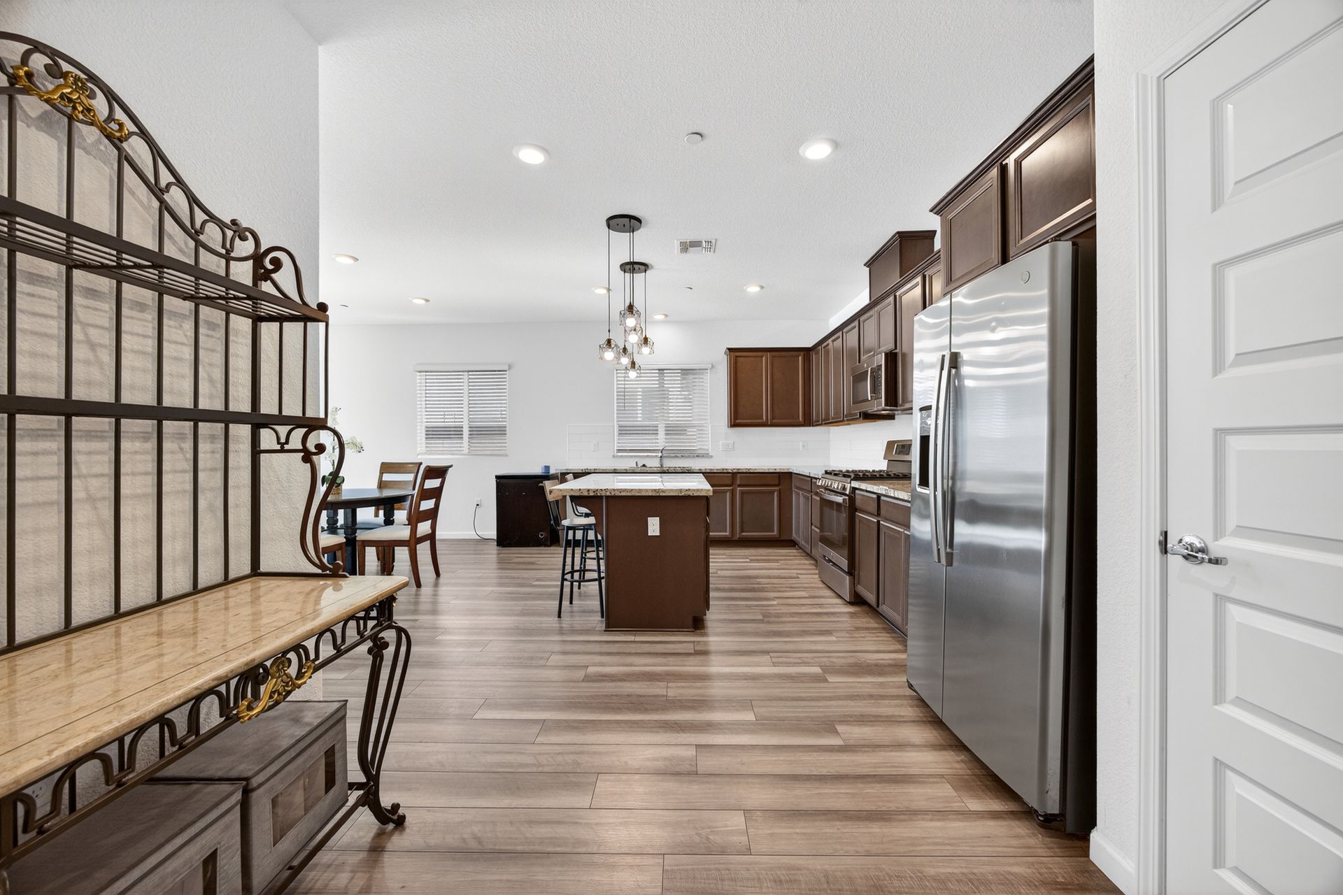 Kitchen with brown cabinets, stainless steel appliances, and wood flooring.