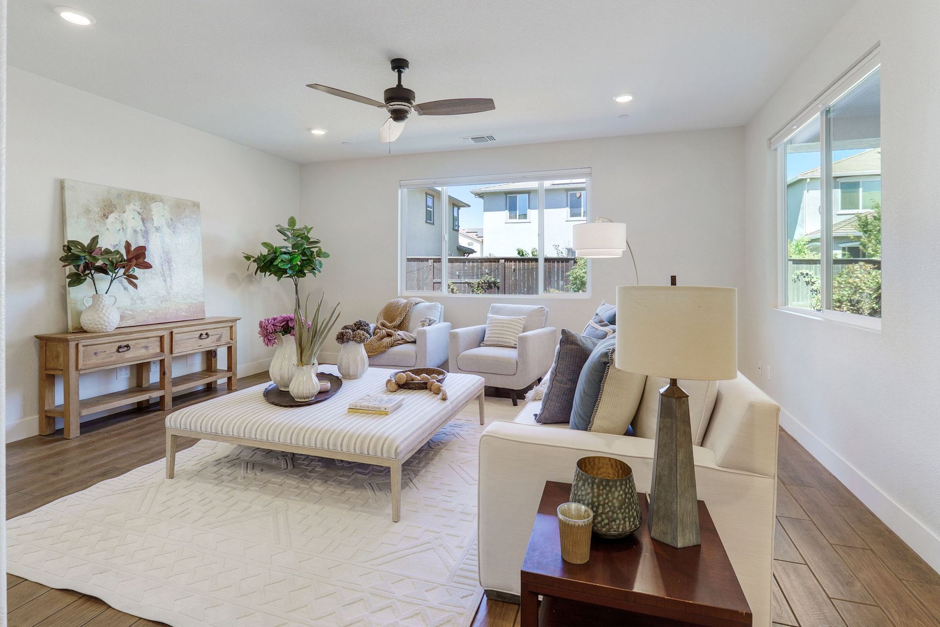 Living room with white walls, light wood floors, and a neutral color scheme.