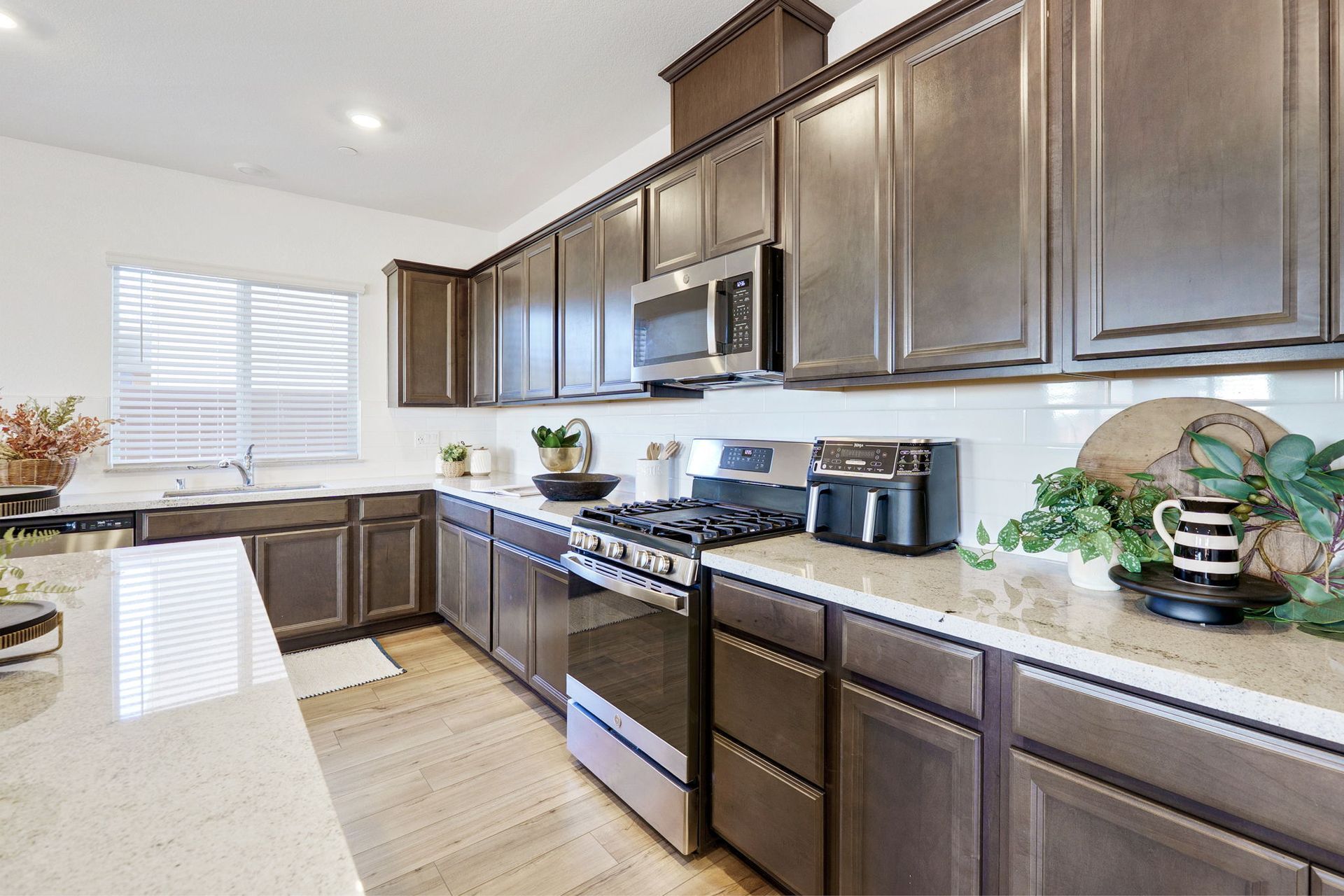 Kitchen with brown cabinets, stainless steel appliances, and white countertops.