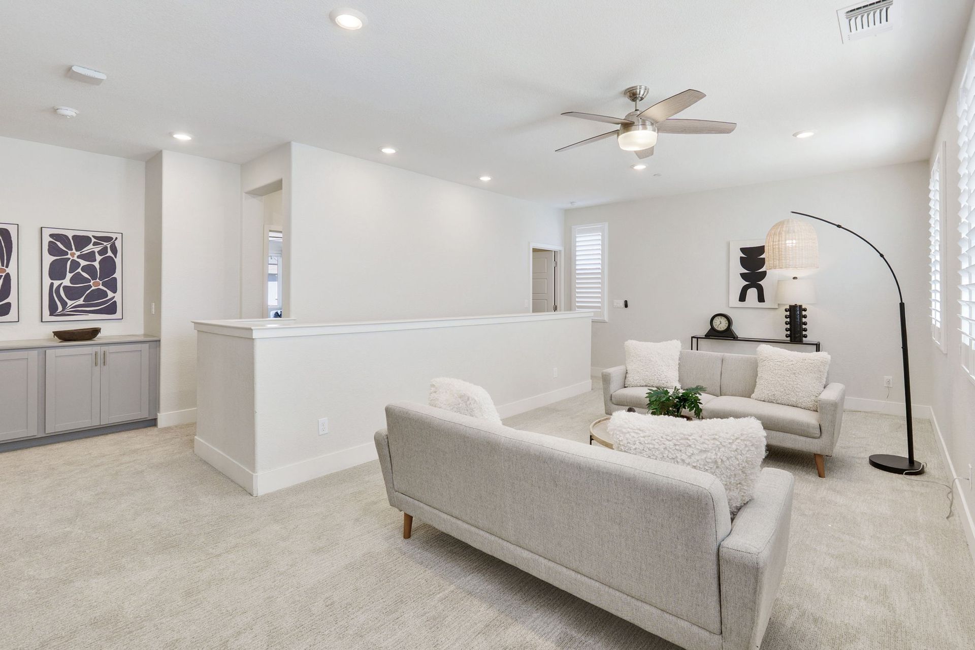 Bright living room with two sofas, decorative art, and a large arched lamp.