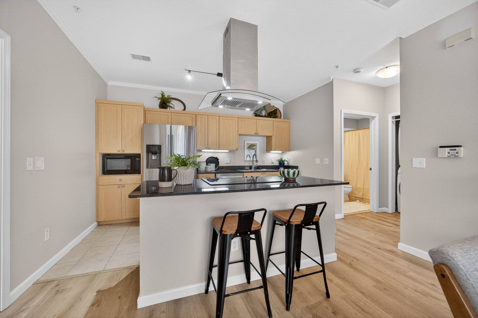 Modern kitchen with island, stainless steel appliances, and wooden cabinets.