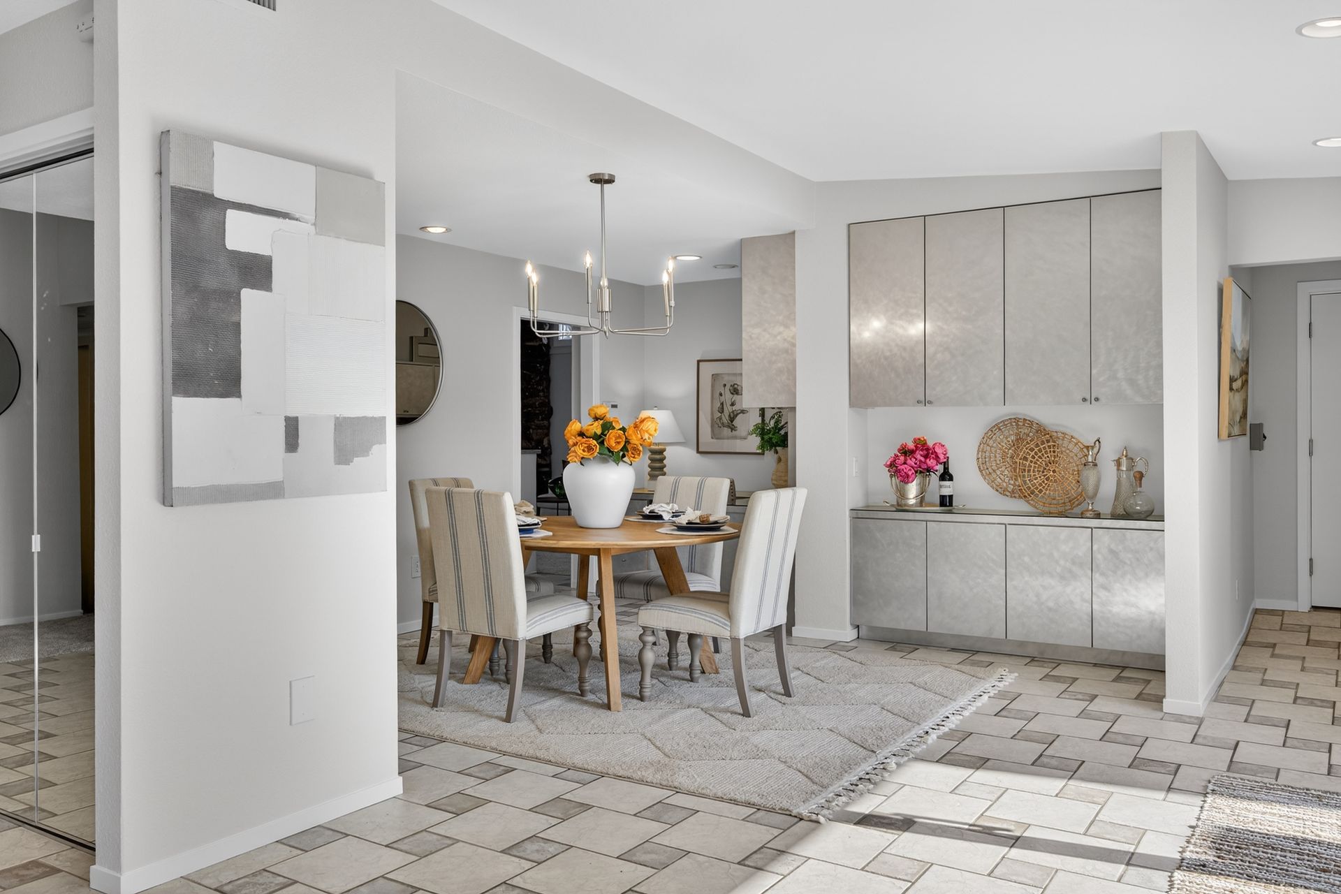 Dining room: light wood table, patterned rug, sideboard, and abstract art.