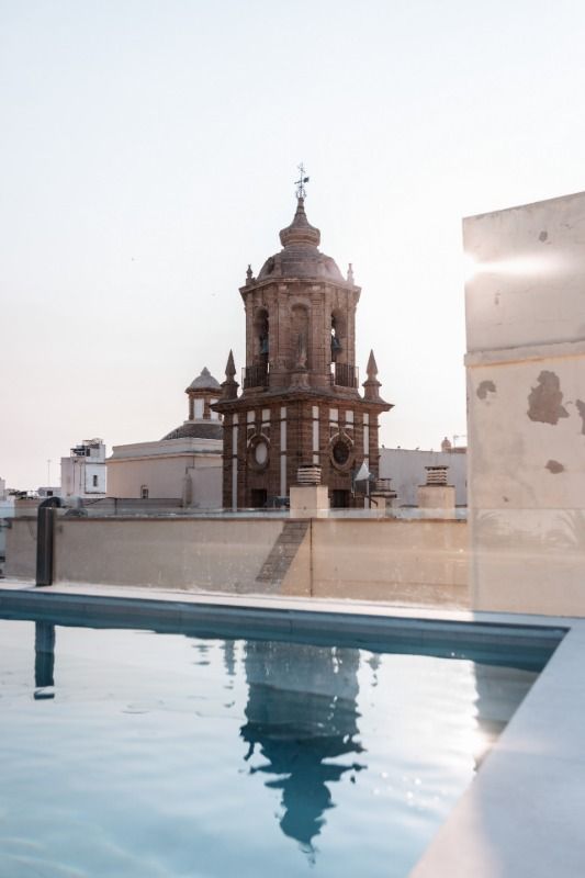 There is a large building in the background and a swimming pool in the foreground.