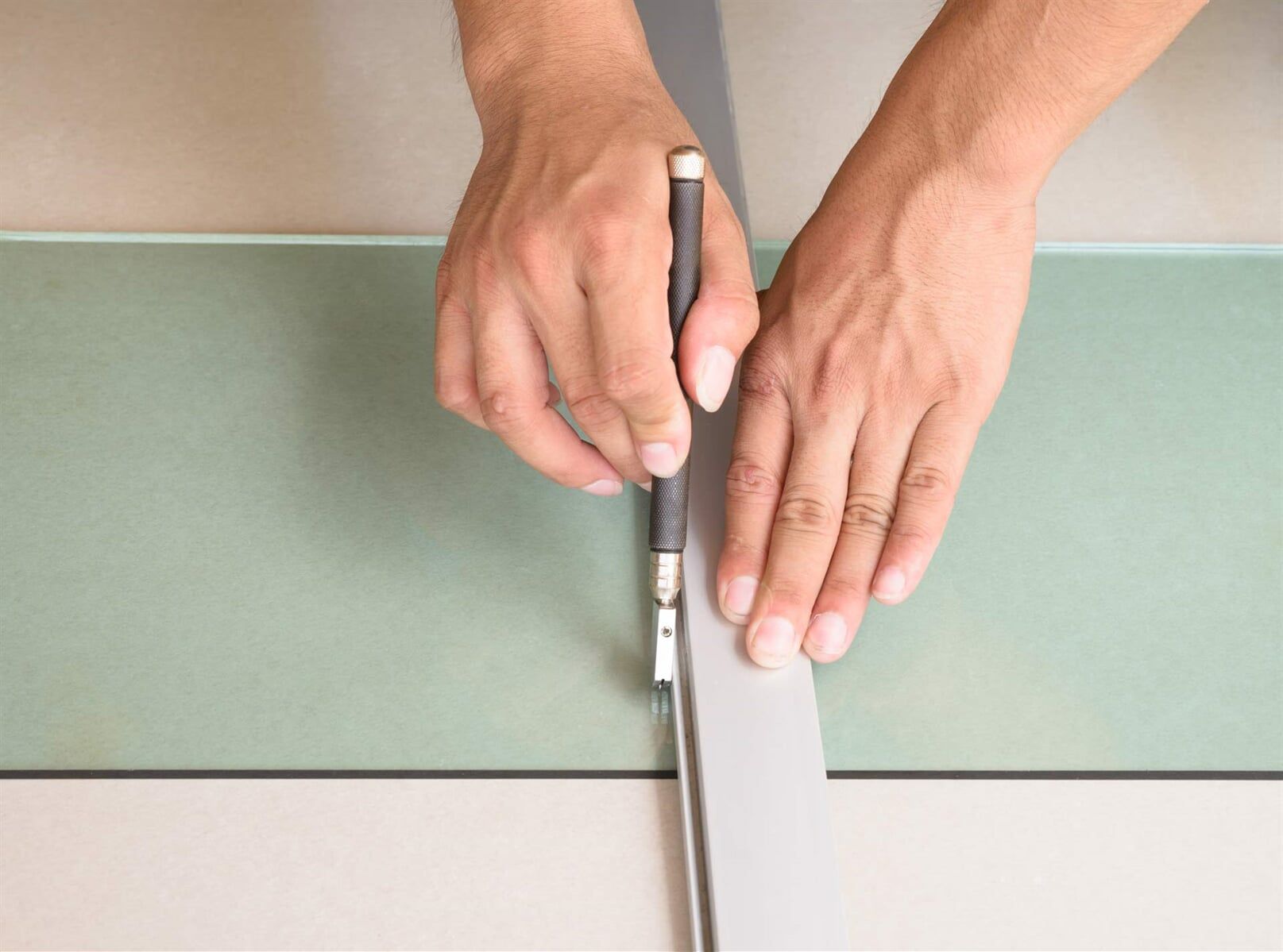 Person is Cutting a Piece of Glass With a Glass Cutter — Glass & Window Centre, Dubbo, NSW