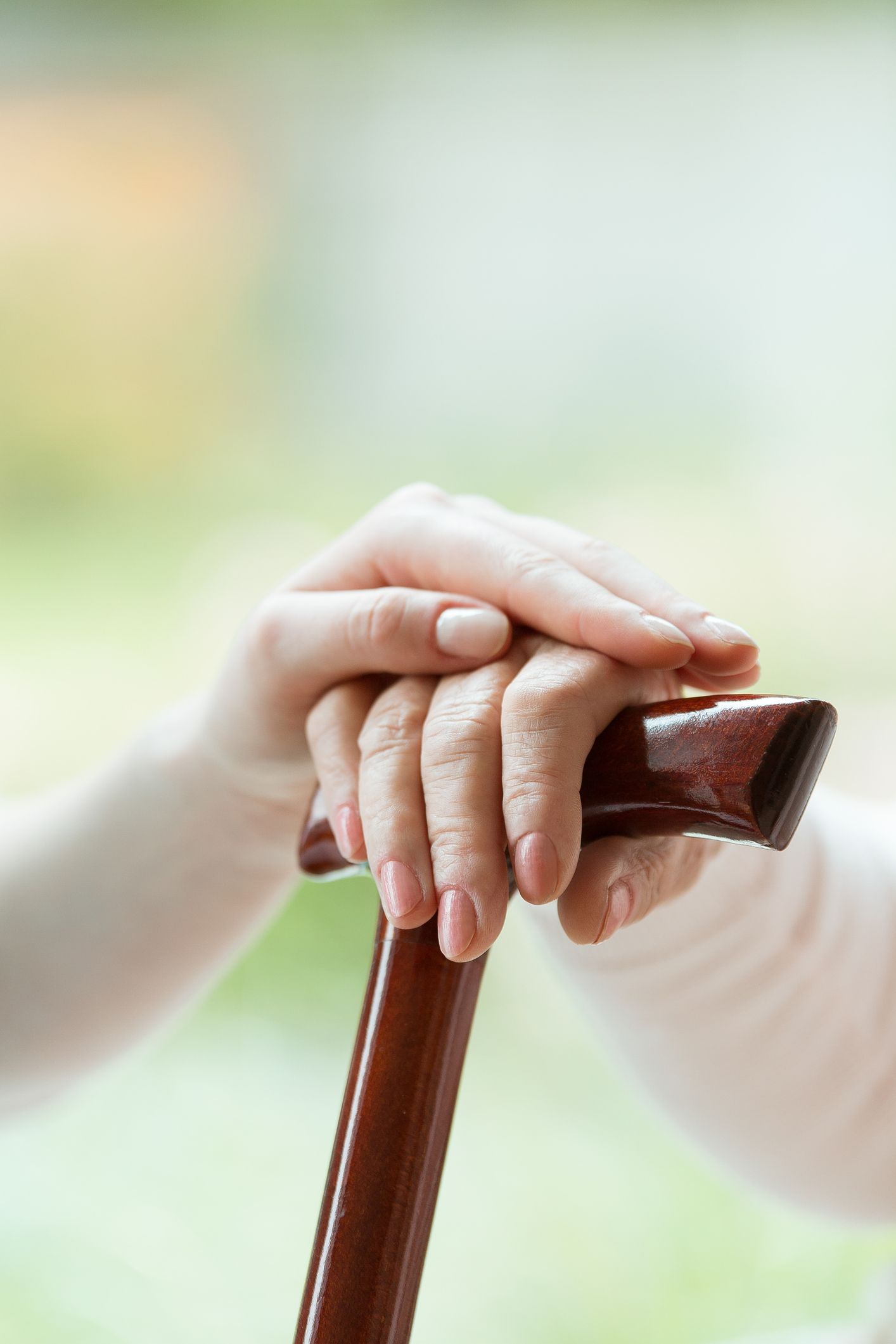 A young woman is holding the hand of an older woman while sitting at a table.