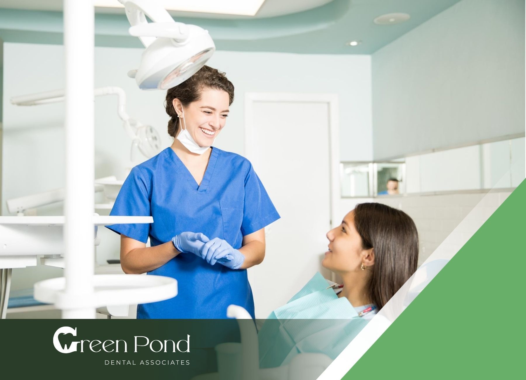 A dentist is talking to a patient in a dental chair.