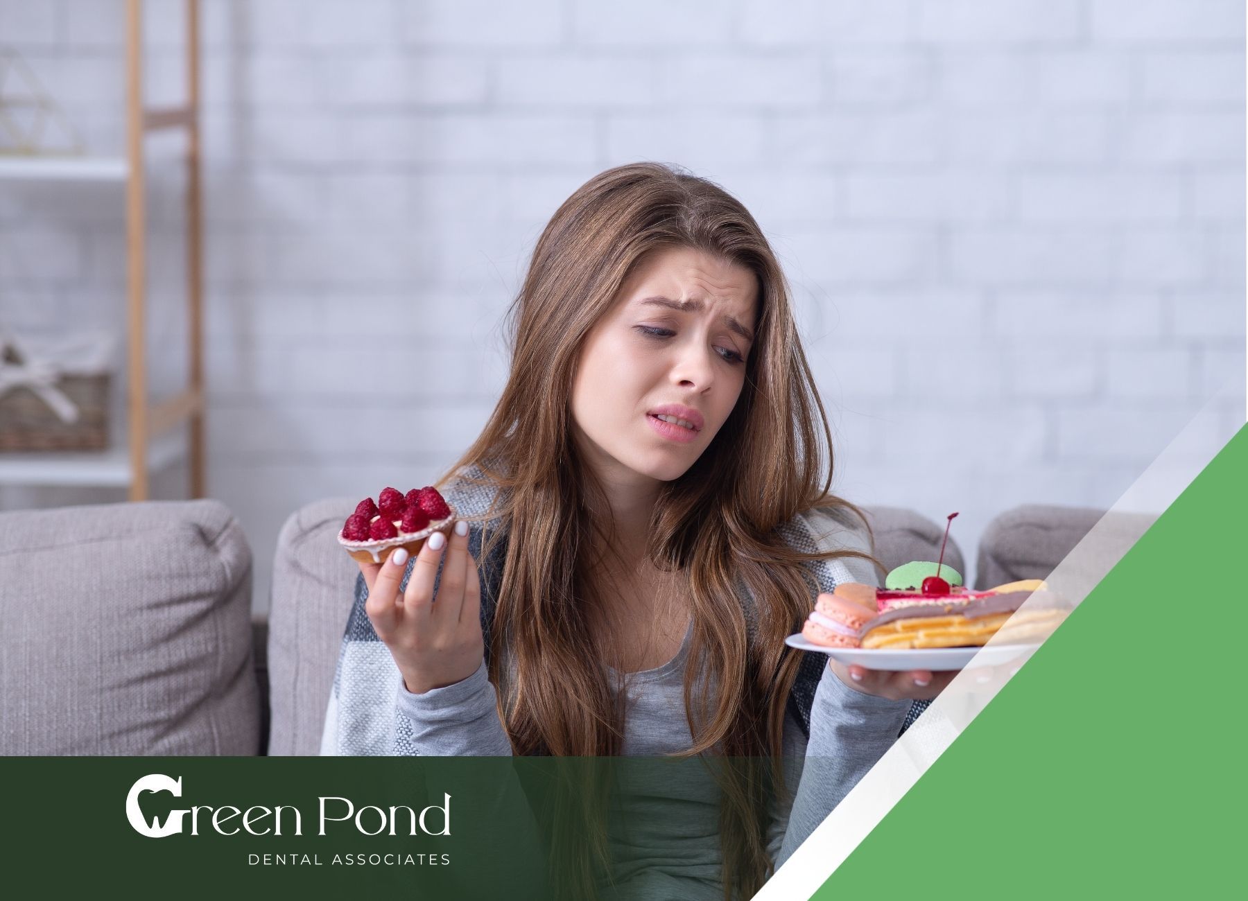 A woman is sitting on a couch holding a plate of food.