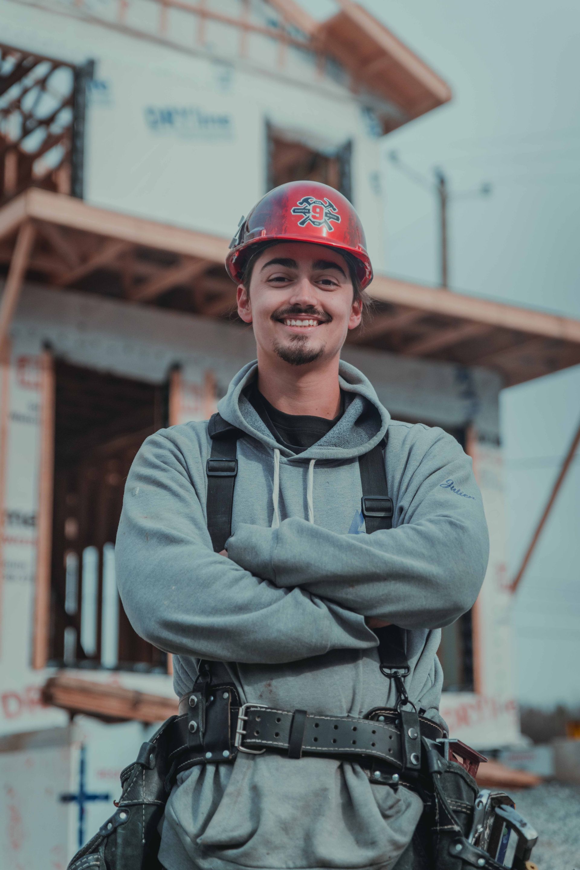 Un jeune homme en chemise noire se tient devant un champ d'herbes hautes.