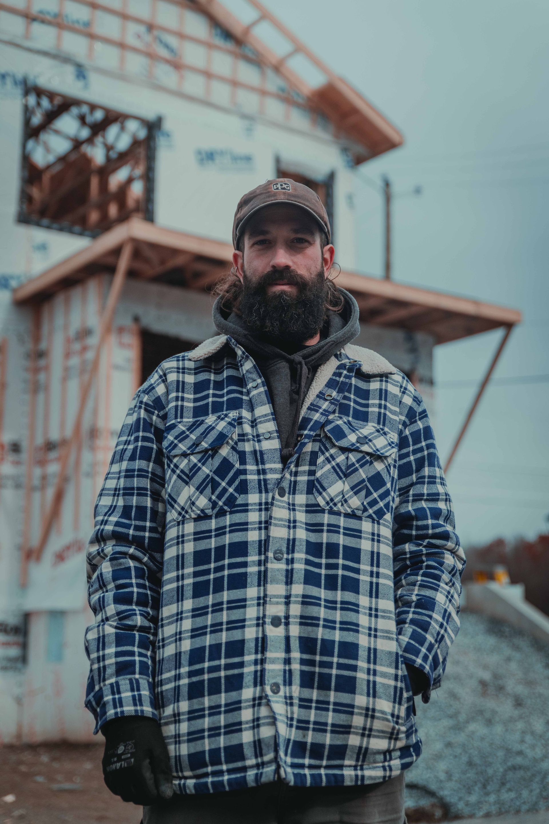 Un homme avec une barbe porte une chemise bleue et sourit.