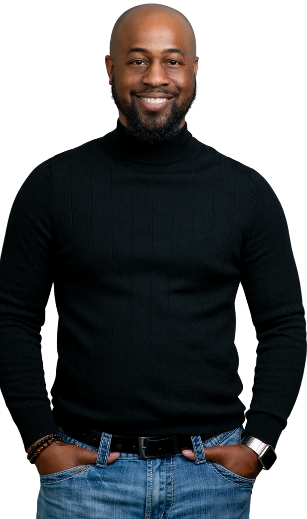 A man wearing a black turtleneck sweater and jeans is standing with his hands in his pockets.