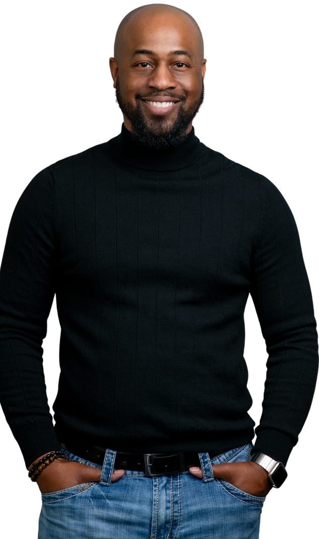 A man wearing a black turtleneck sweater and jeans is standing with his hands in his pockets.