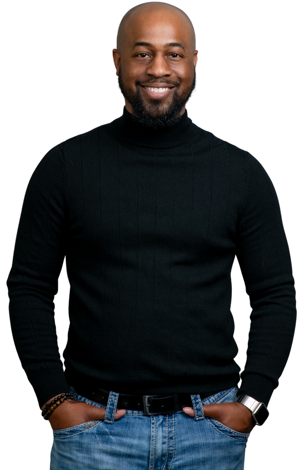 A man wearing a black turtleneck sweater and jeans is standing with his hands in his pockets.