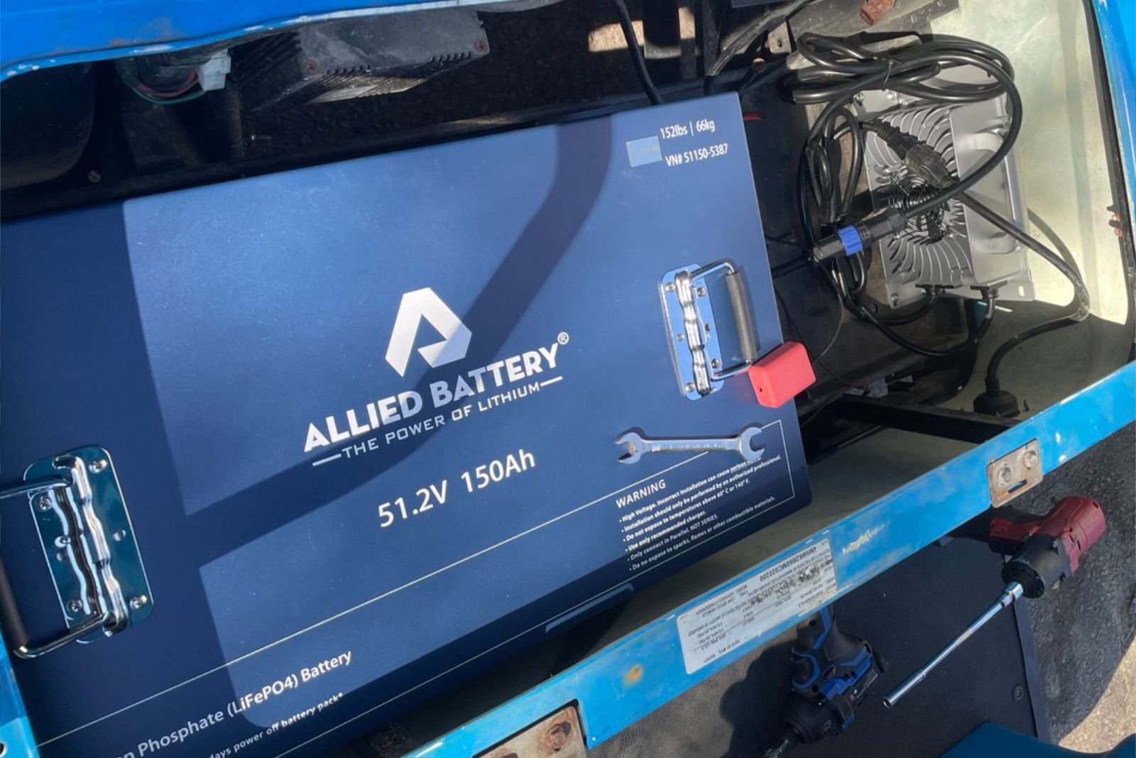 Blue box containing a large Allied Battery, 51.2V 150Ah, with a wrench and screwdriver.