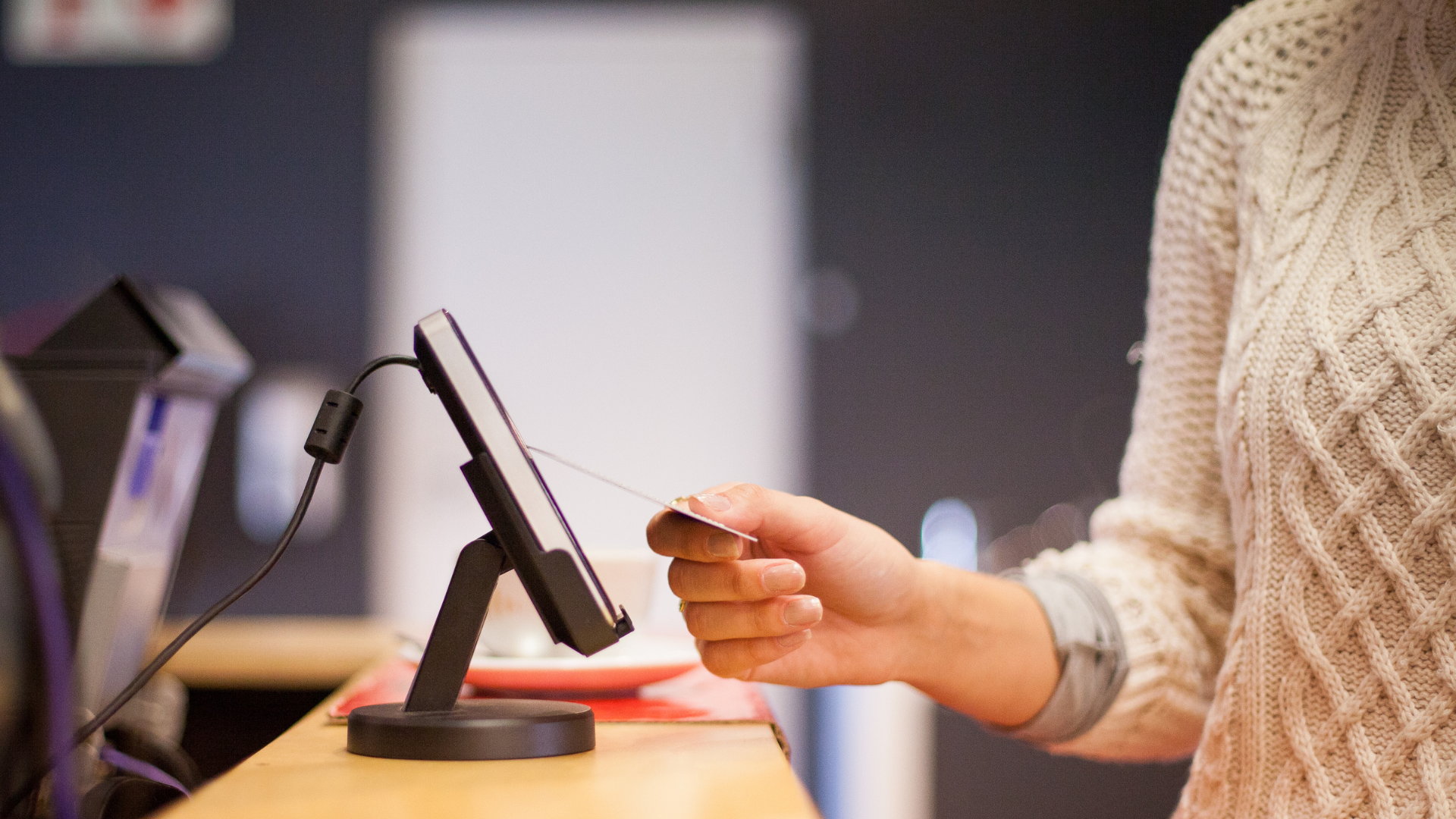 A woman is using a credit card to pay for something.