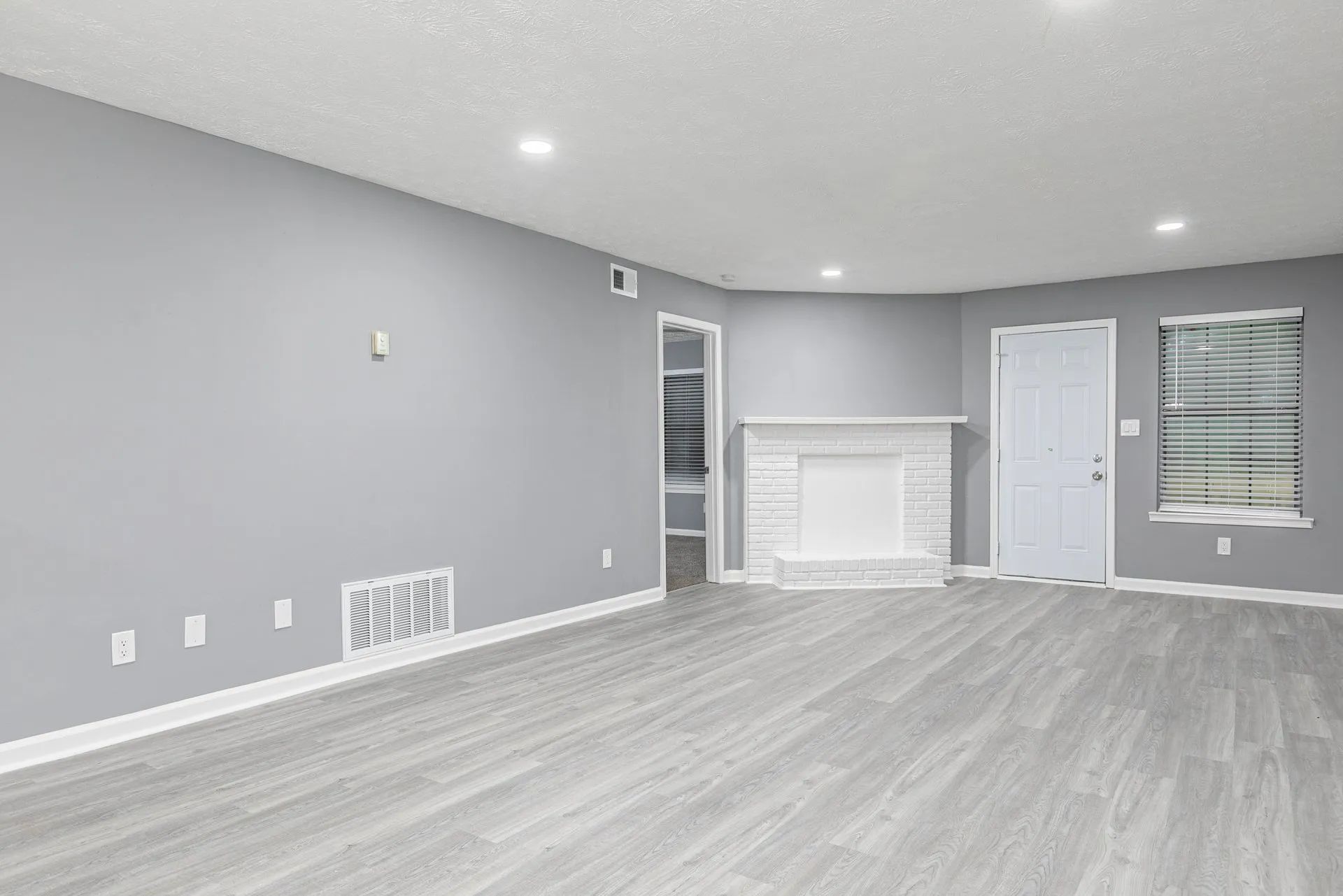 Dog-Friendly Apartments In Riverdale, CA - Briar Hill 563 - Spacious Living Room With Recessed Lighting, Vinyl Plank Flooring, And Fireplace.