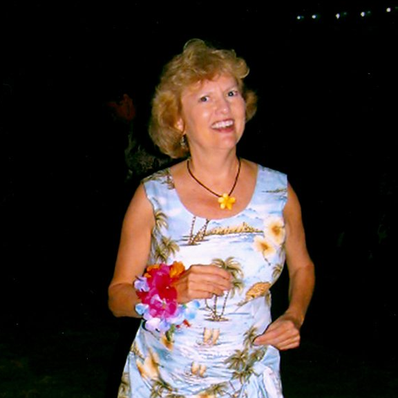 a woman in a hawaiian dress is smiling at the camera