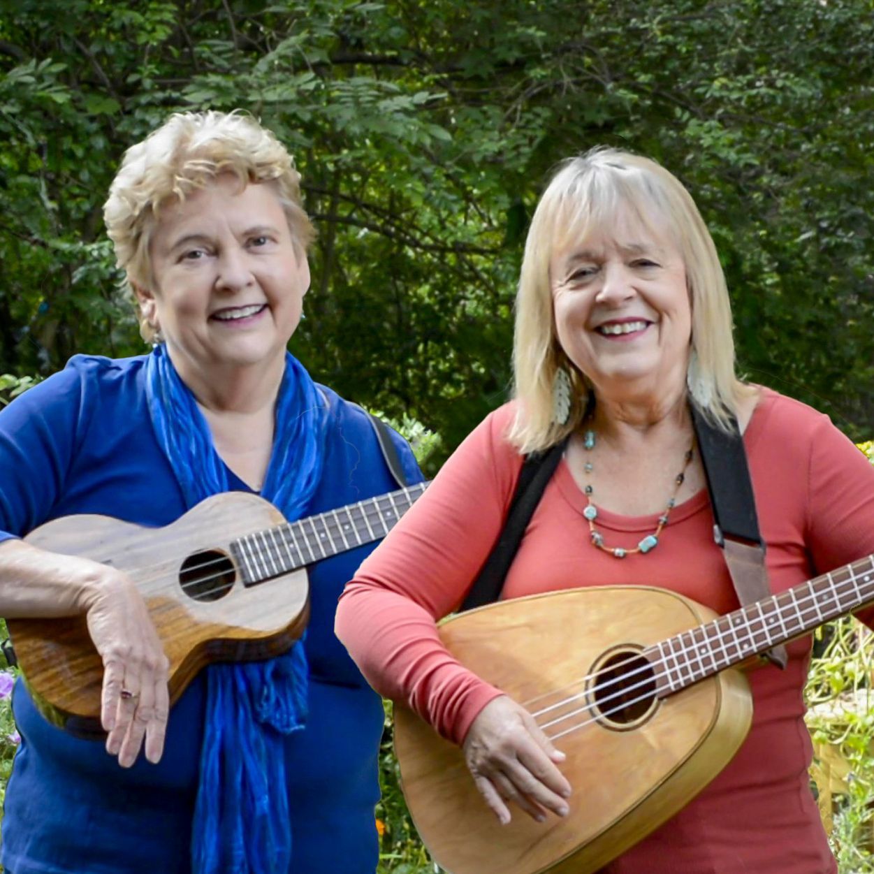 two women standing next to each other playing ukuleles and smiling