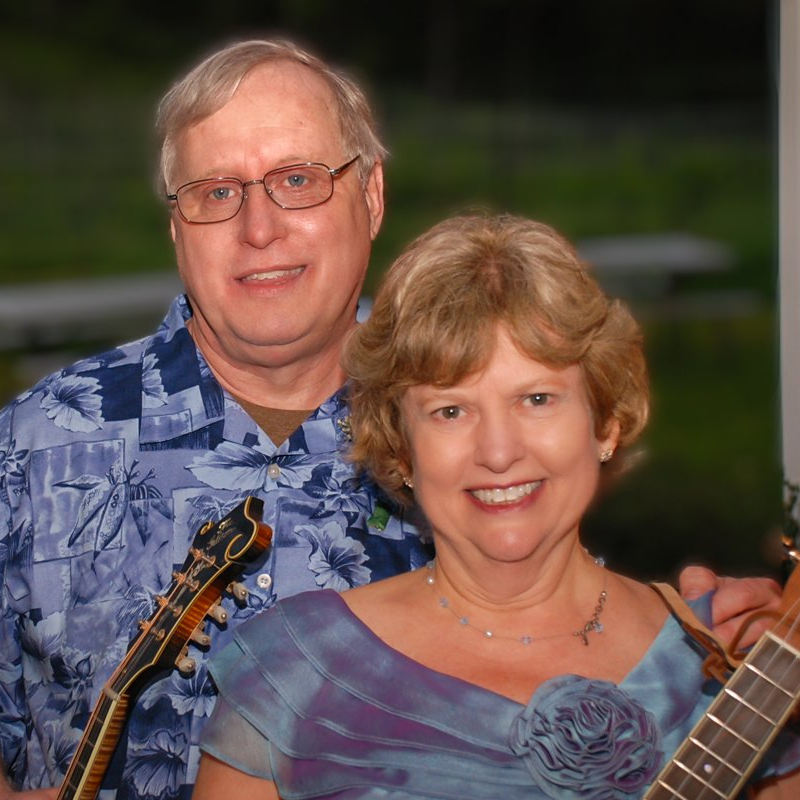 a man and a woman are posing for a picture and the woman is holding a guitar