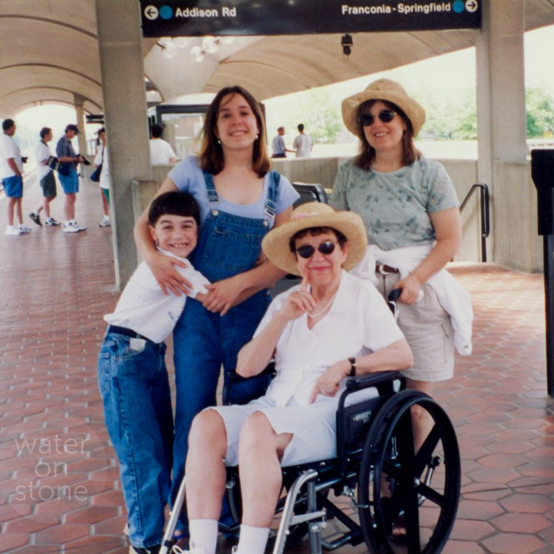 a woman in a wheelchair is surrounded by three other people at the metro station
