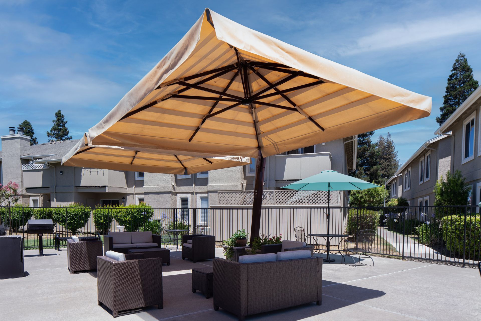 Round wooden coffee table in a living room with a gray sofa and sheer curtains.