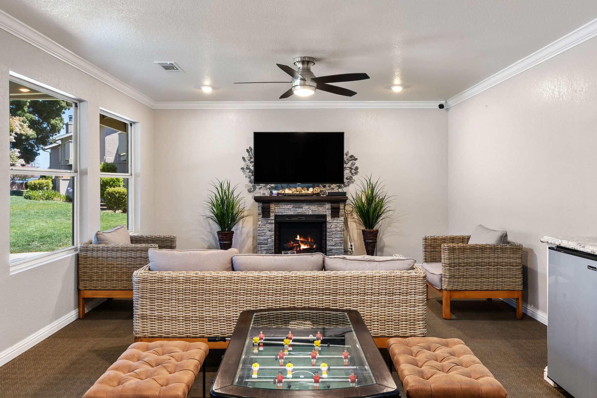 Cozy lounge area with fireplace, foosball table, seating, and TV.