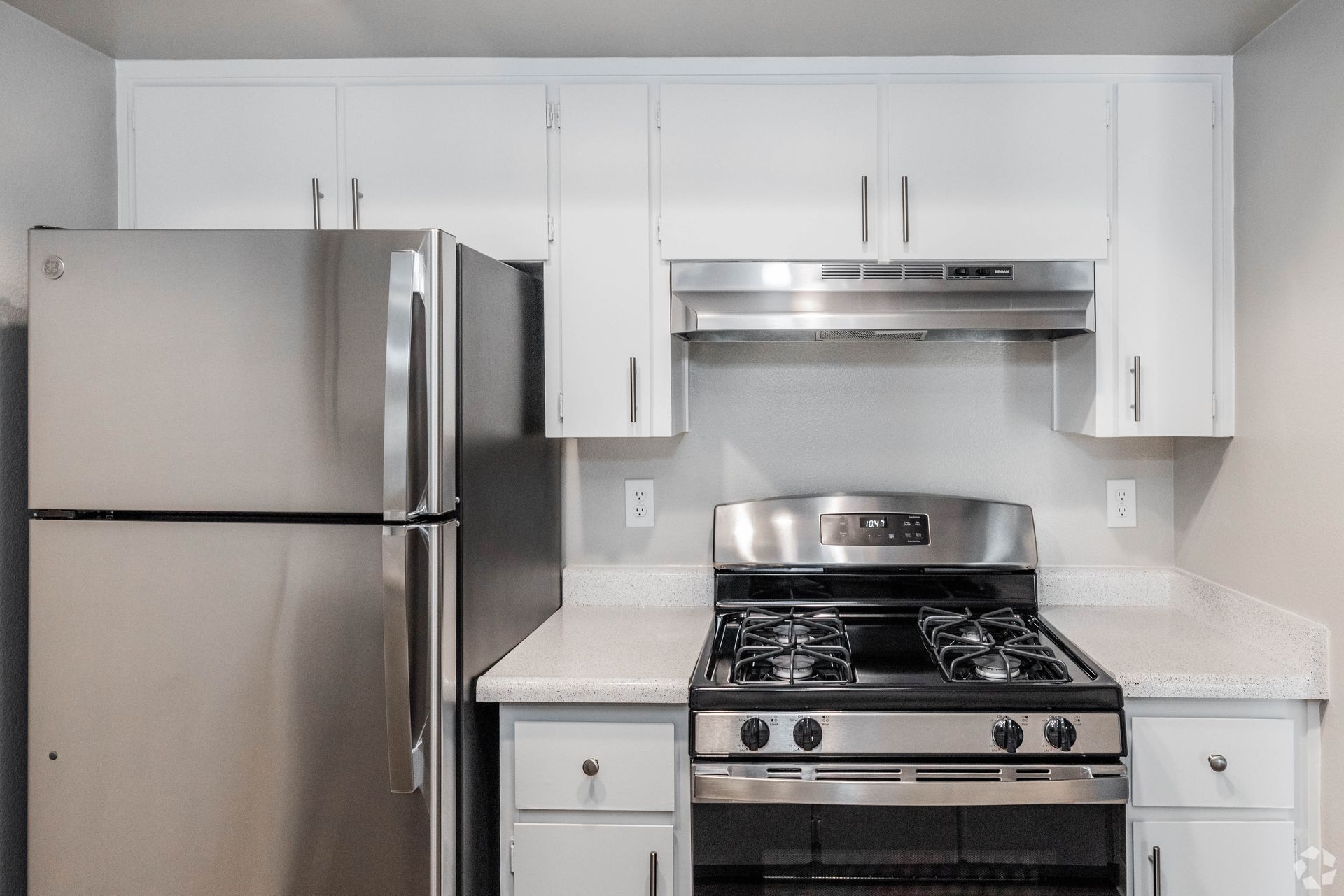 Stainless steel kitchen appliances in a white kitchen.
