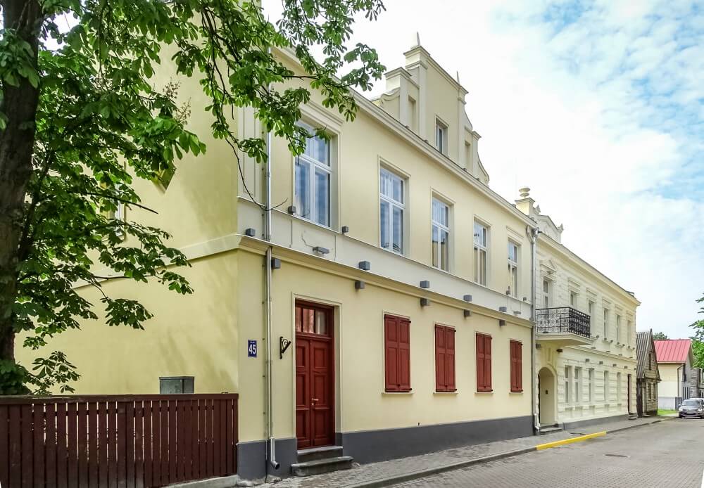Stone house with yellow finish and red doors