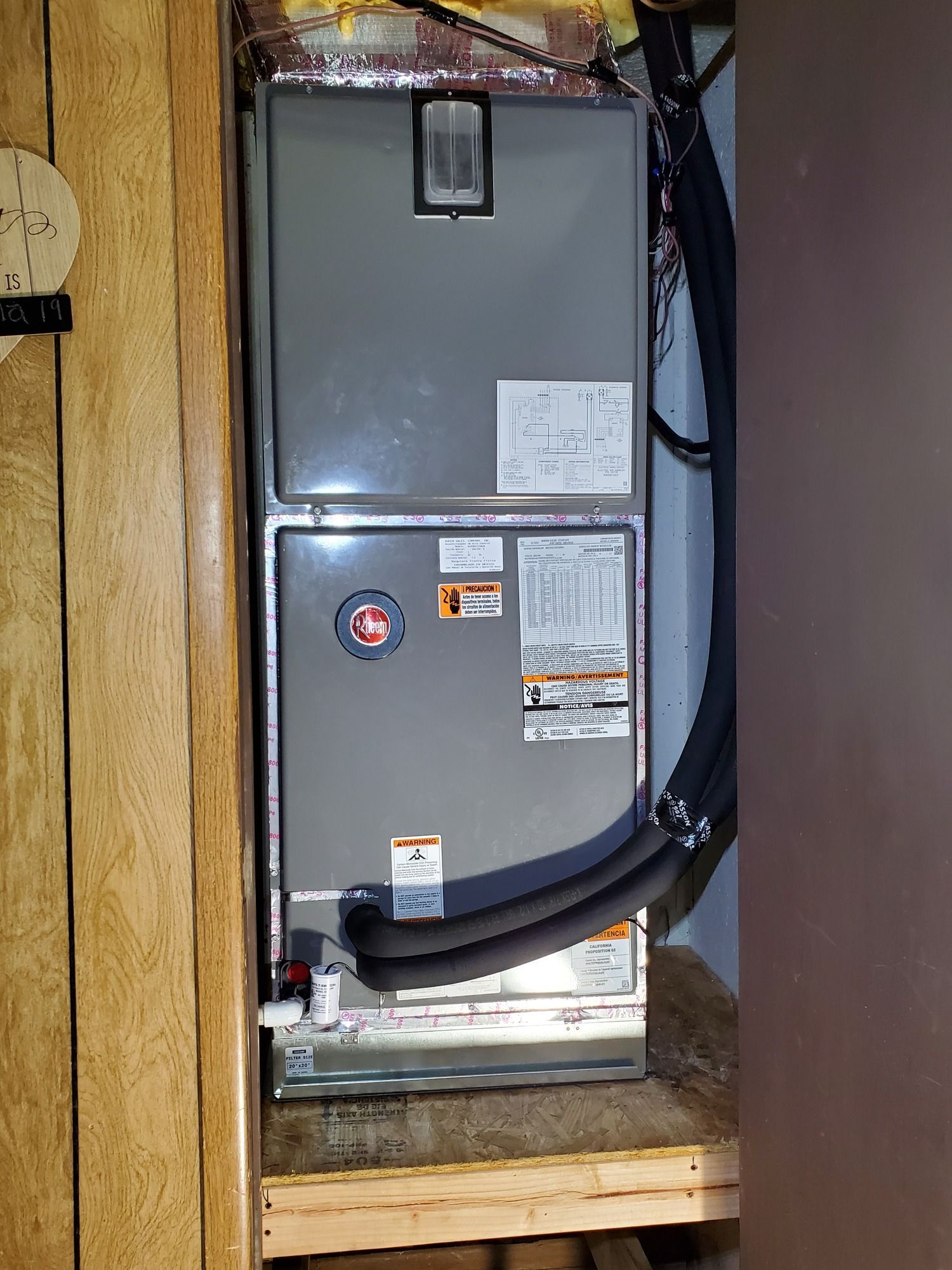 An air conditioner is sitting in a closet next to a wall.