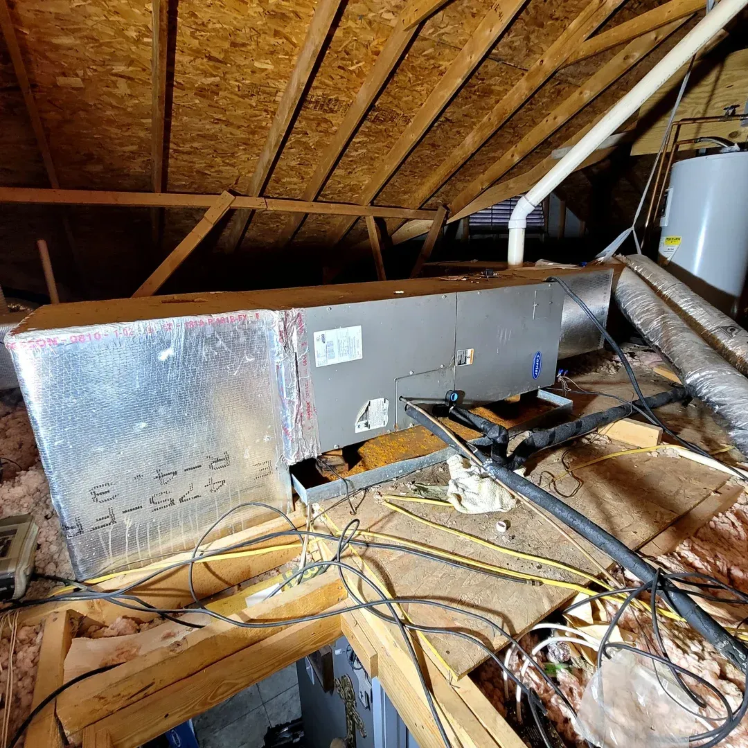 Two air conditioners are sitting outside of a house.