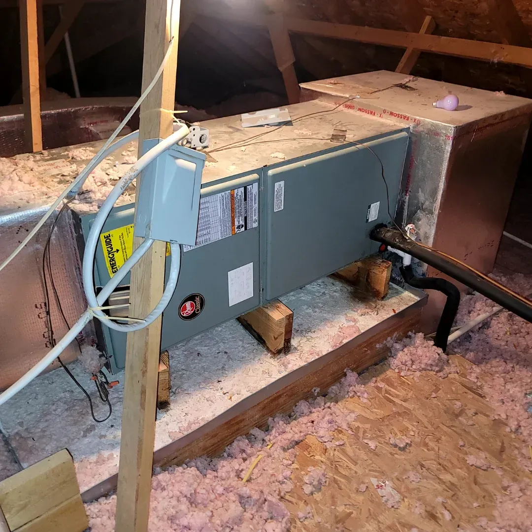 Two air conditioners are sitting outside of a house.