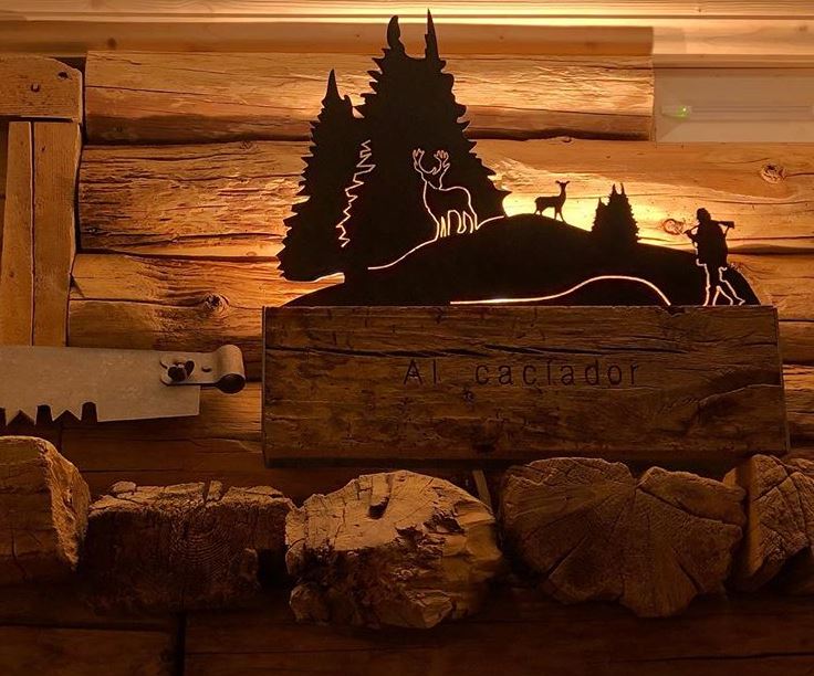 Una scatola di legno con la sagoma di un cervo e degli alberi sopra