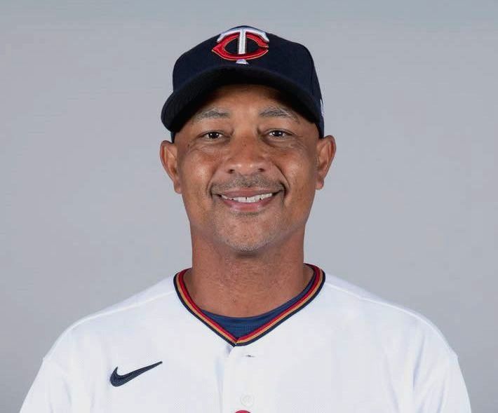 Minnesota Twins manager Rocco Baldelli smiling, wearing a team cap and jersey.