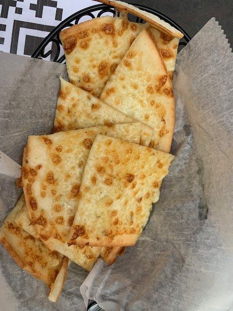 A basket filled with slices of cheese bread