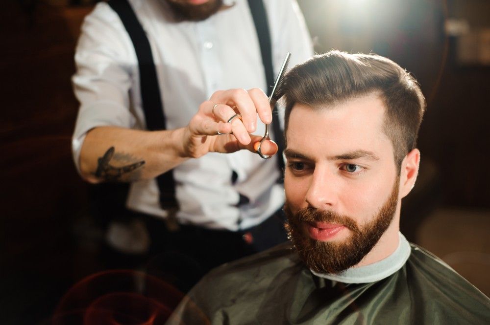 A Man is Getting His Hair Cut by a Barber With White Shirt — Fraser Shores Hair Design In Urraween, QLD