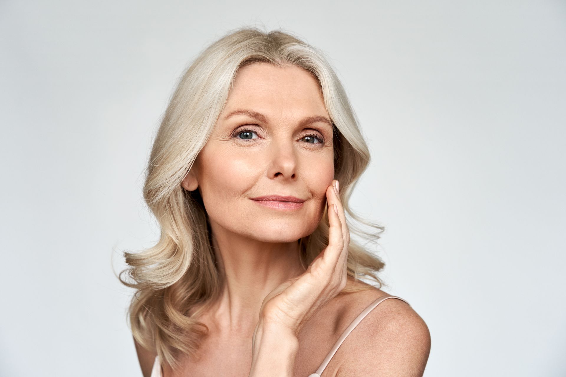 Smiling Silver-haired Woman Resting Her Hand on Her Cheek — Fraser Shores Hair Design In Urraween, QLD