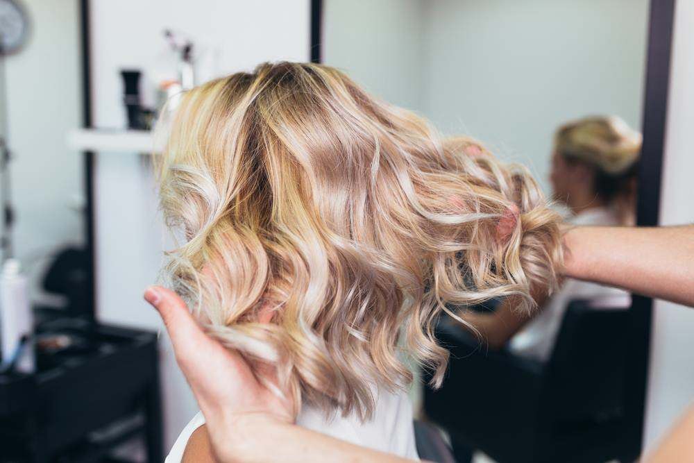 Blonde Wavy Bob Hairstyle Being Styled in A Salon — Fraser Shores Hair Design In Urraween, QLD