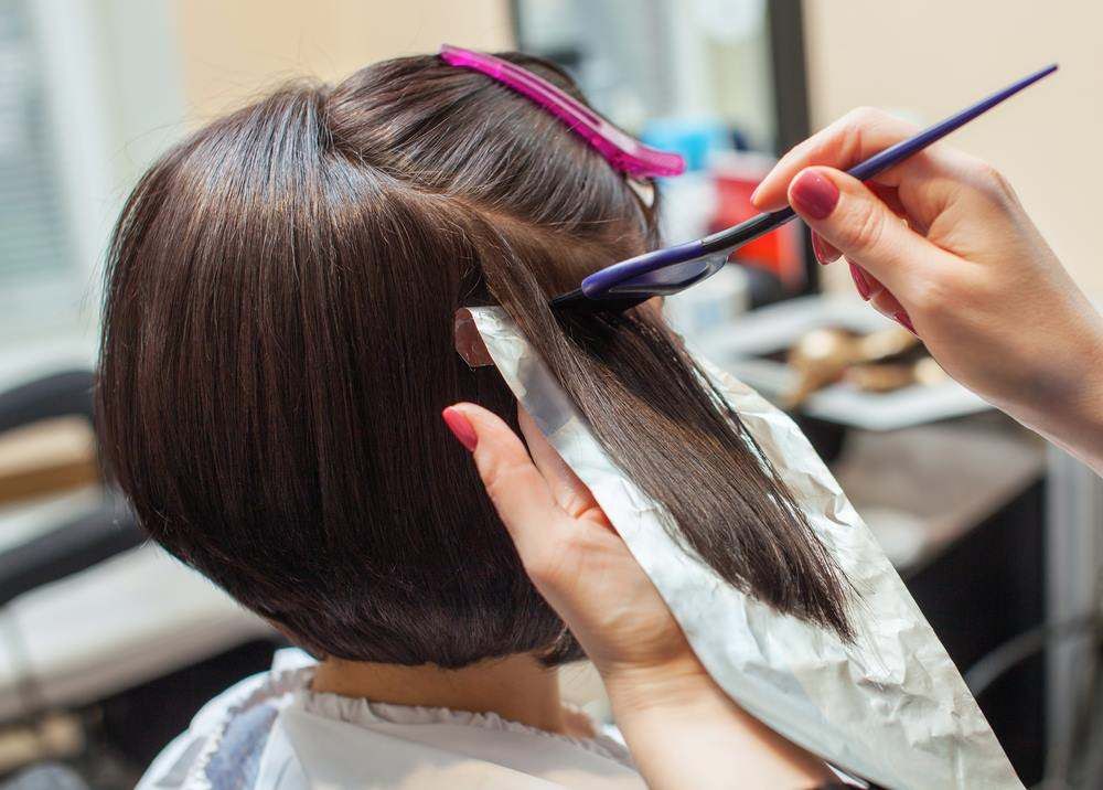 Hairdresser Trimming a Brunette Bob with Scissors and Comb — Fraser Shores Hair Design In Urraween, QLD