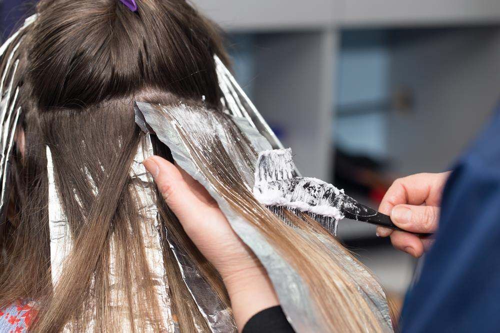 Hair Stylist Applying Silver Dye to Long Hair with A Brush and Foil — Fraser Shores Hair Design In Urraween, QLD