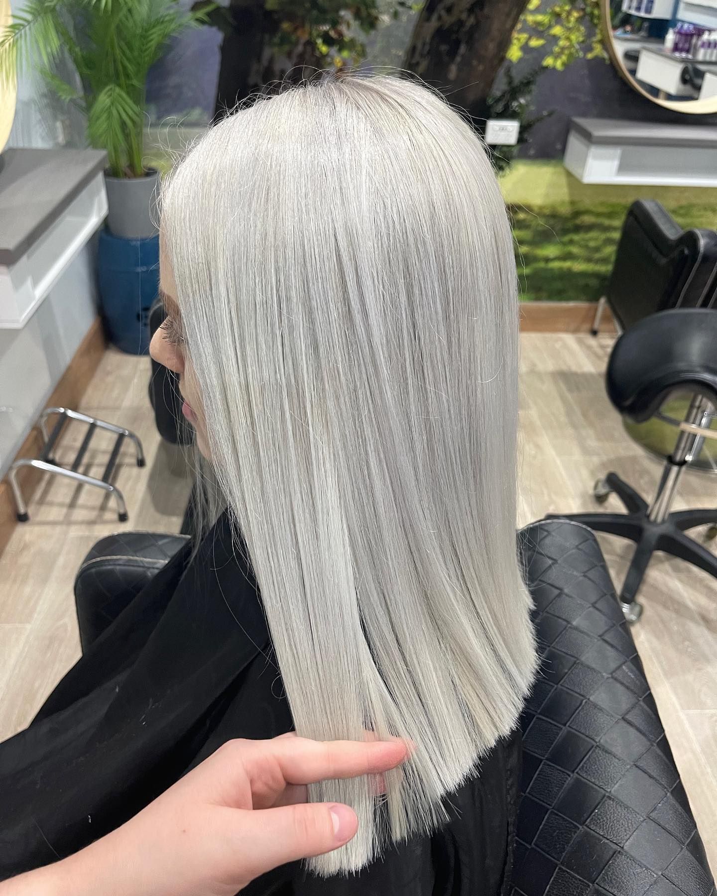 A Woman With White Hair is Sitting in a Chair at a Hair Salon — Fraser Shores Hair Design in Fraser Coast, QLD