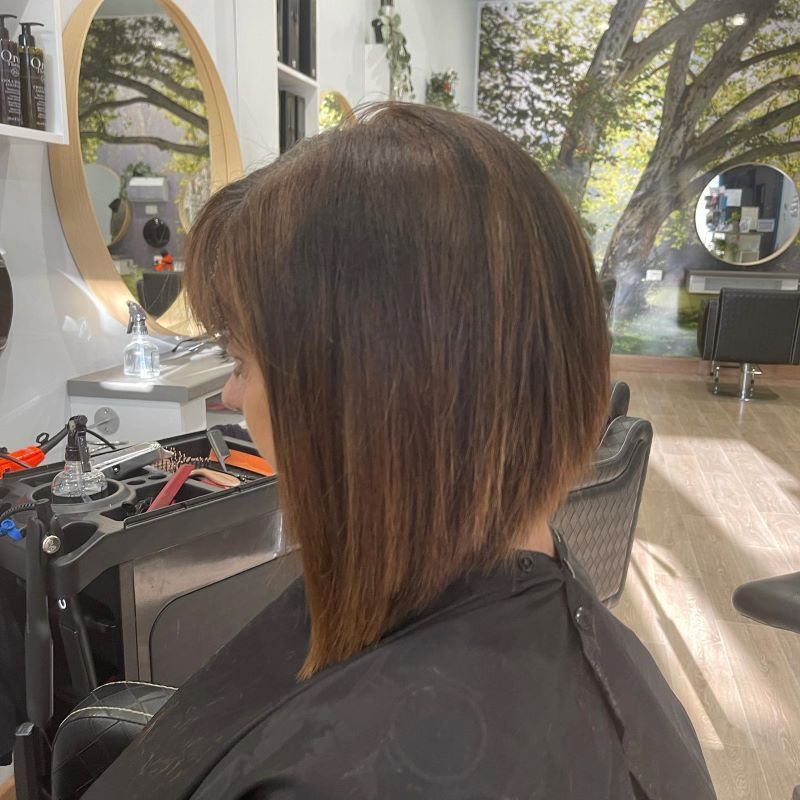 A Woman Is Getting Her Hair Cut — Fraser Shores Hair Design in Urraween, QLD
