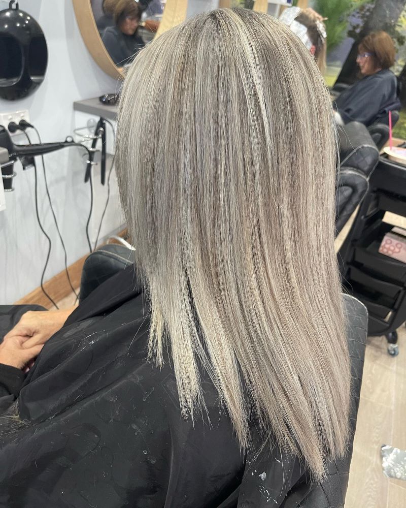 A Woman is Getting Her Hair Cut in a Salon — Fraser Shores Hair Design in Fraser Coast, QLD