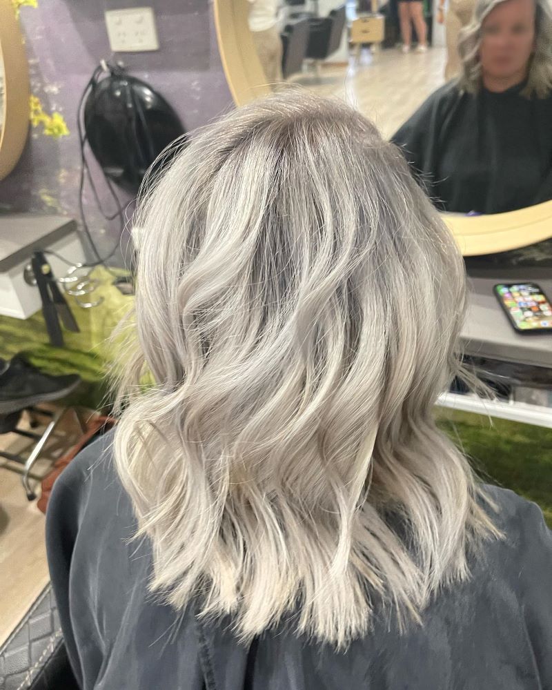 A Woman with Blonde Hair Is Sitting in A Chair — Fraser Shores Hair Design in Urraween, QLD