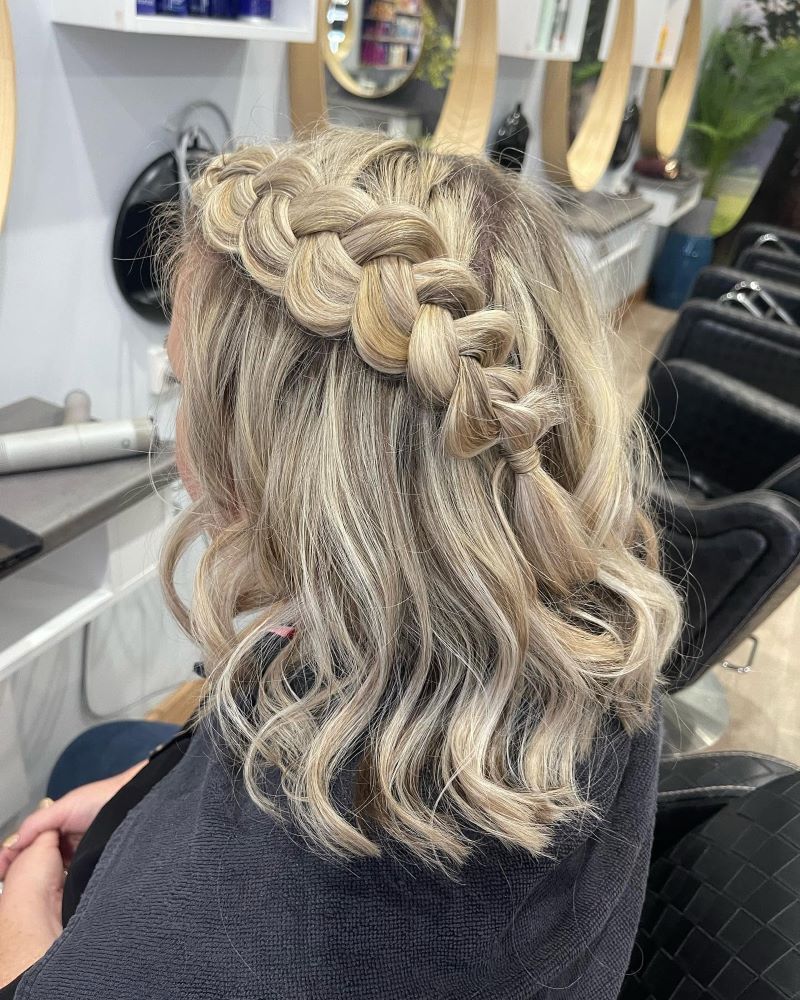 A Woman Is Getting Her Hair Braided in A Salon — Fraser Shores Hair Design in Urraween, QLD