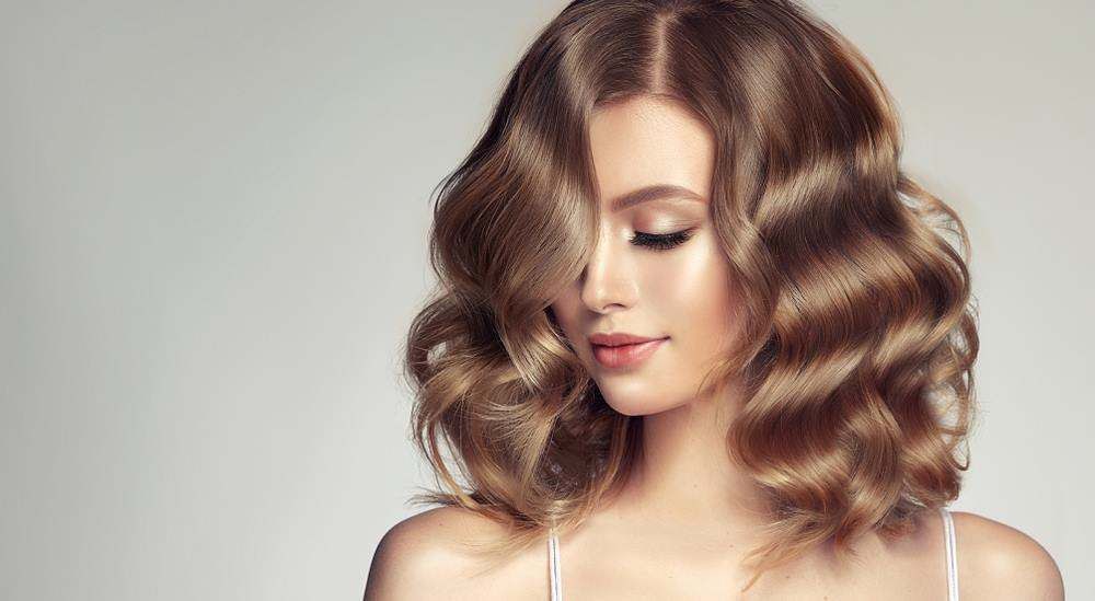 Woman with Shoulder-Length Wavy Brown Hair Looking Down — Fraser Shores Hair Design In Urraween, QLD